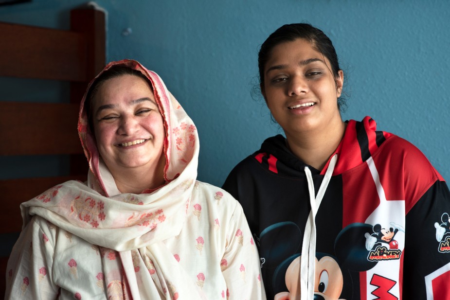 A mother and her daughter, who she cares for, smile for the camera