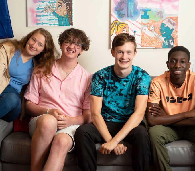 A diverse group of young carers smile at the camera