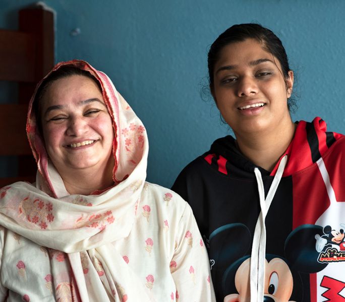 A mother and daughter smile at the camera