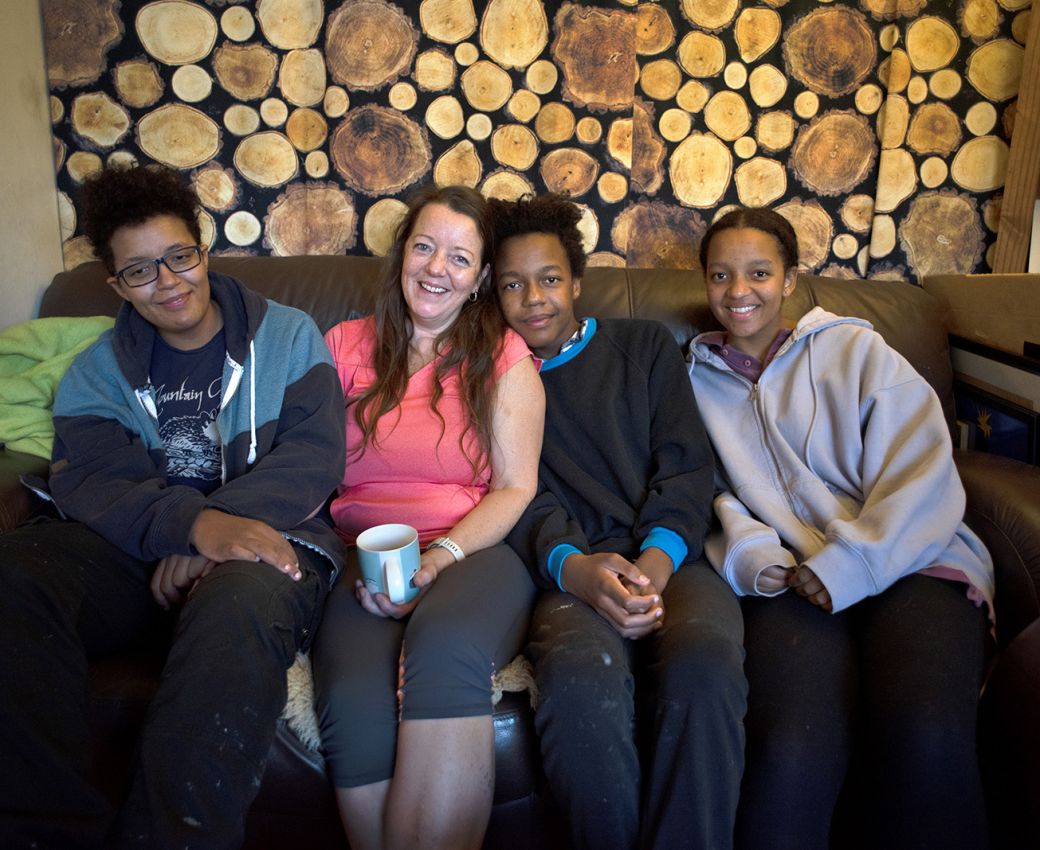 A family sitting together on a couch smiling at the camera