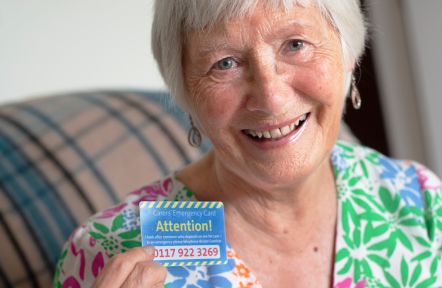 A carer shows her Carers Emergency Card to the camera