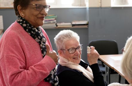 Two women carers greet each other at the start of a support group meeting