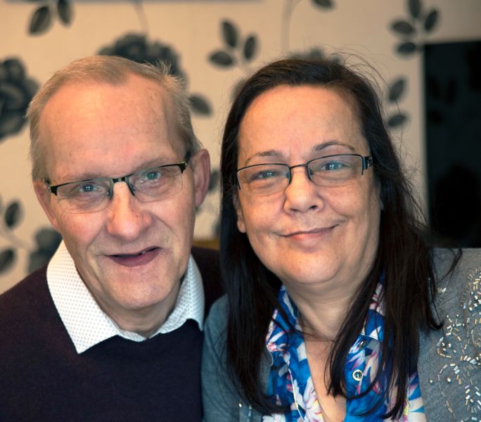 A caring couple smile at the camera