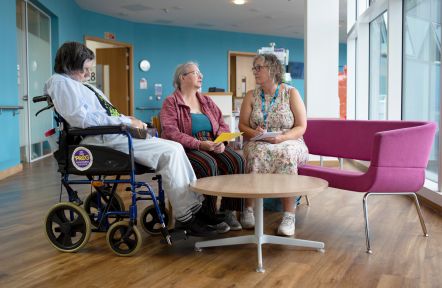 A carer support office having a discussion in a hospital with a carer and their cared-for