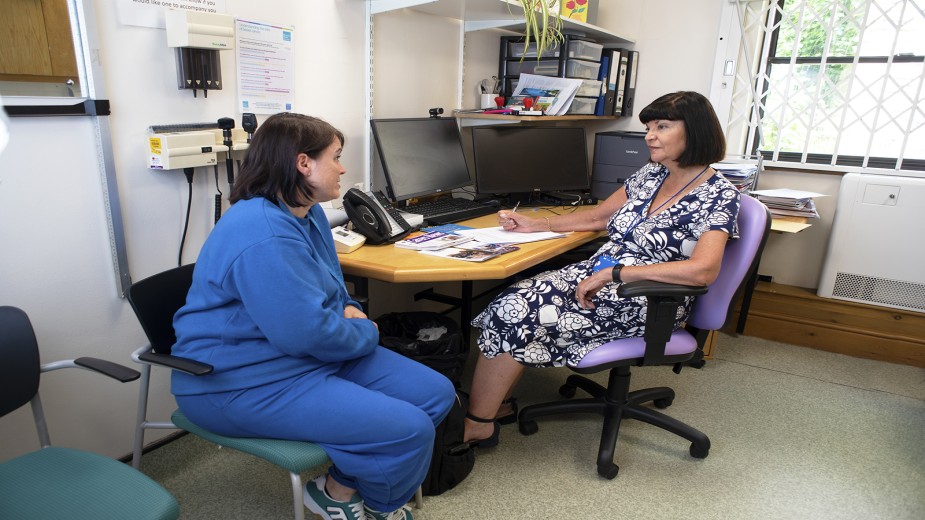 A  GP Carer Liaison Worker talks with a patient in a local surgery