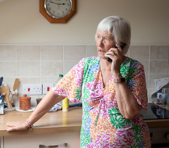 A woman on the phone in her kitchen