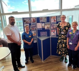 Hospital staff standing beside a carers information display during a carers awareness event on Ward 34 at Southmead Hospital.