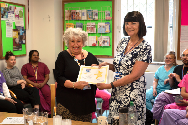 A Carers Liaison  Worker presents the Montpelier Health Centre with a GP award