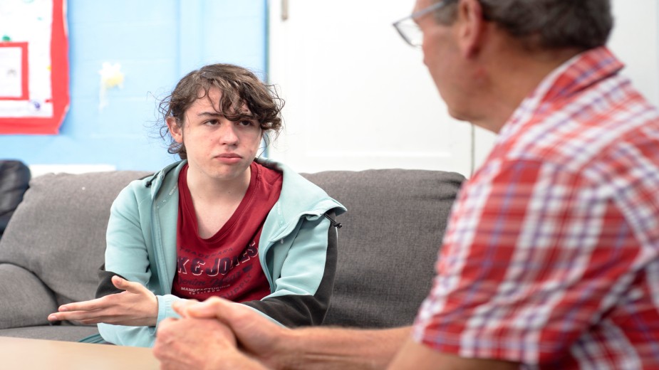 A care worker talks with a young carer